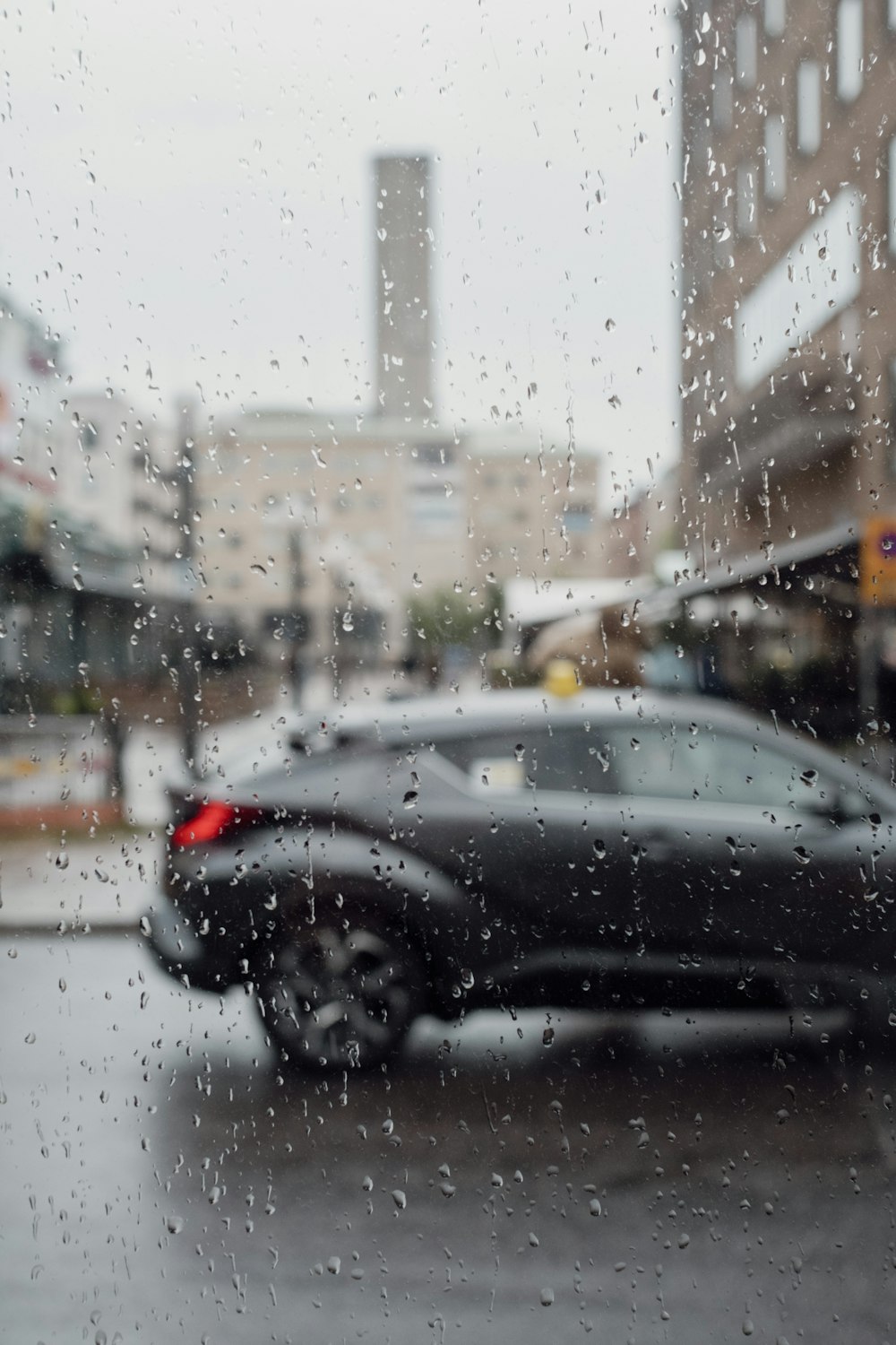 a black car driving down a street next to a tall building