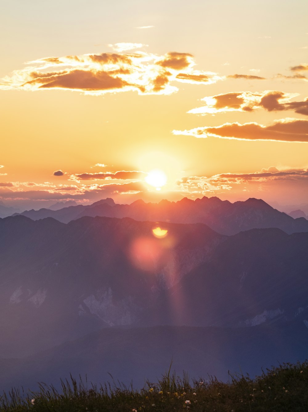 the sun is setting over a mountain range