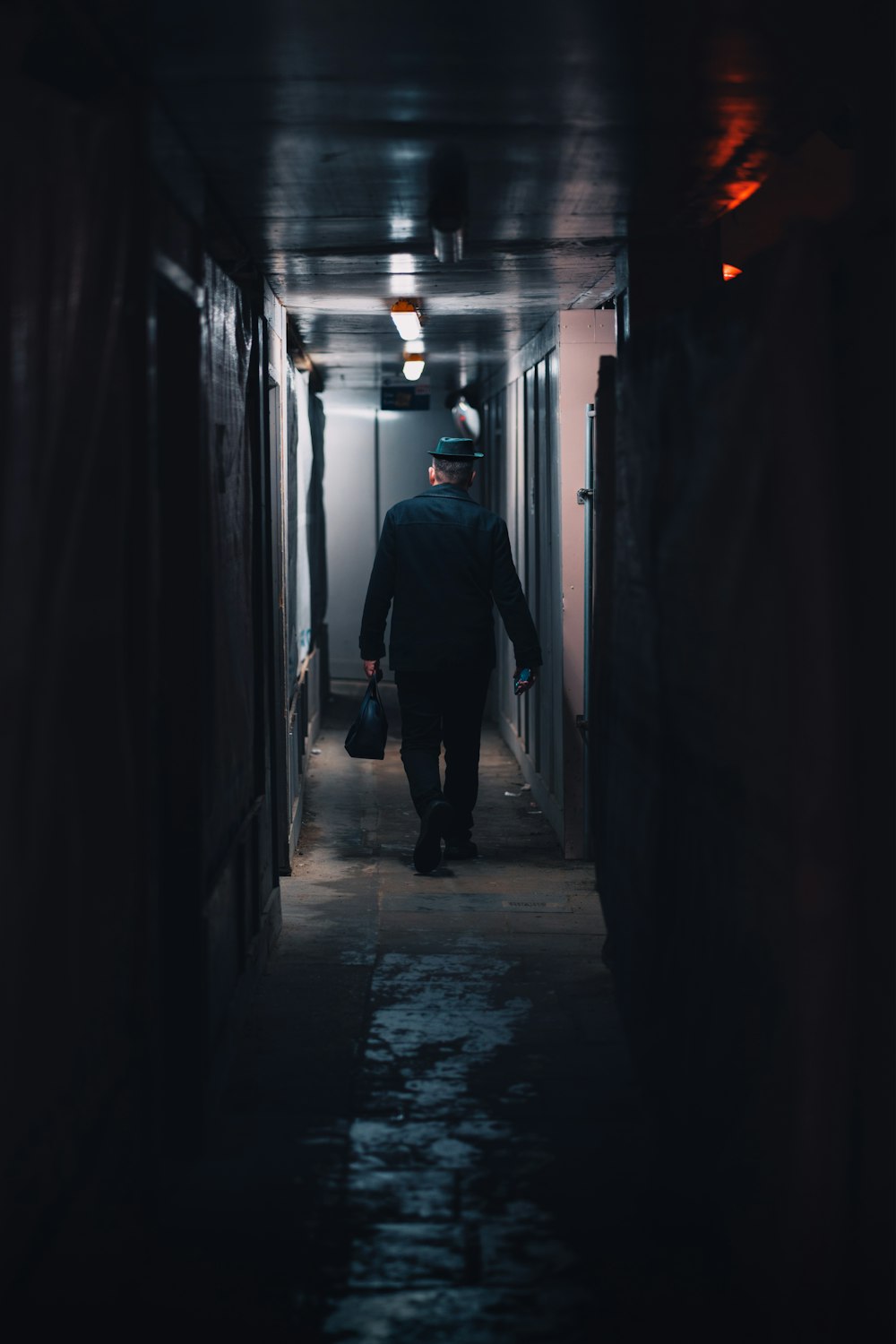a man is walking down a dark hallway