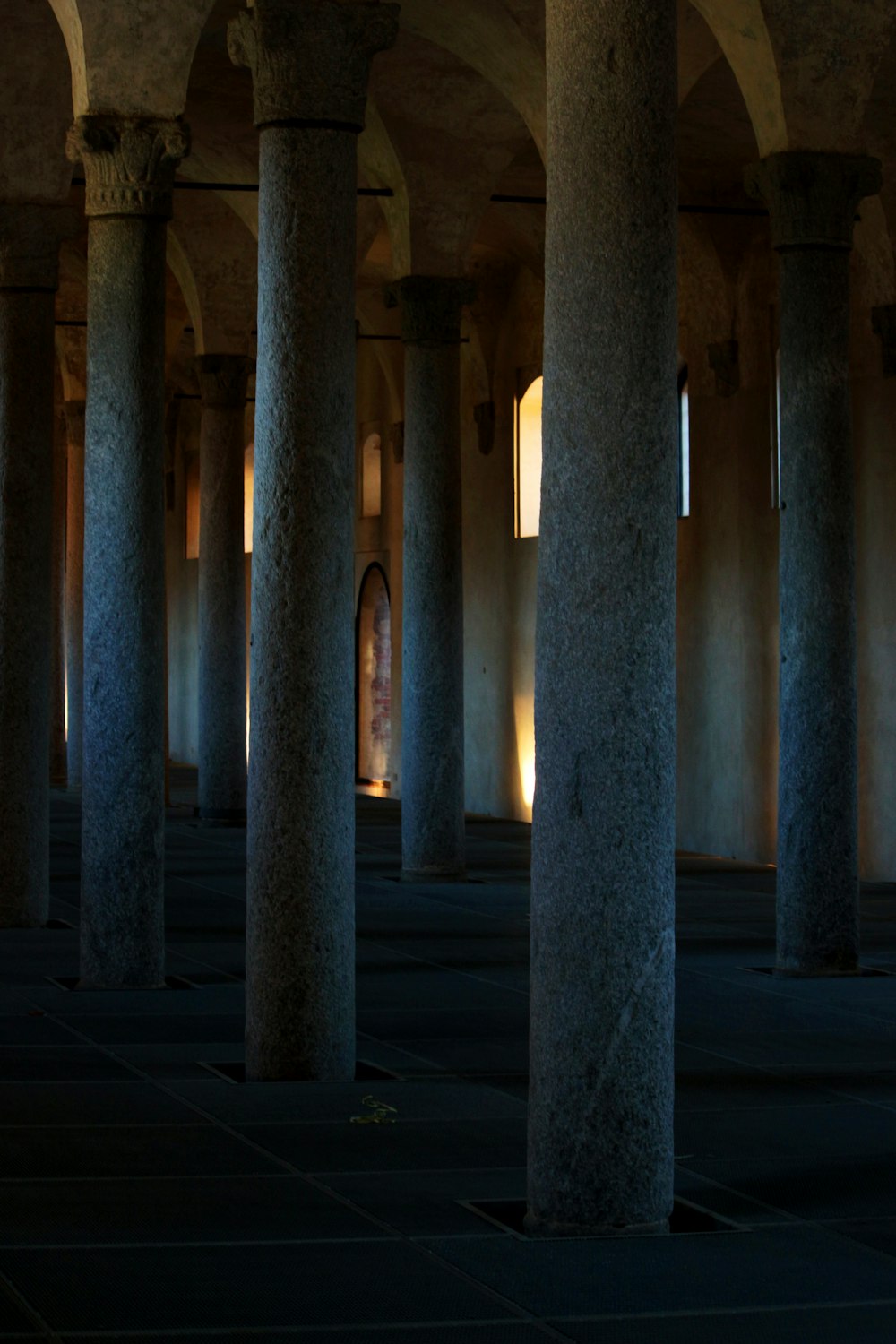 an empty room with columns and a clock on the wall