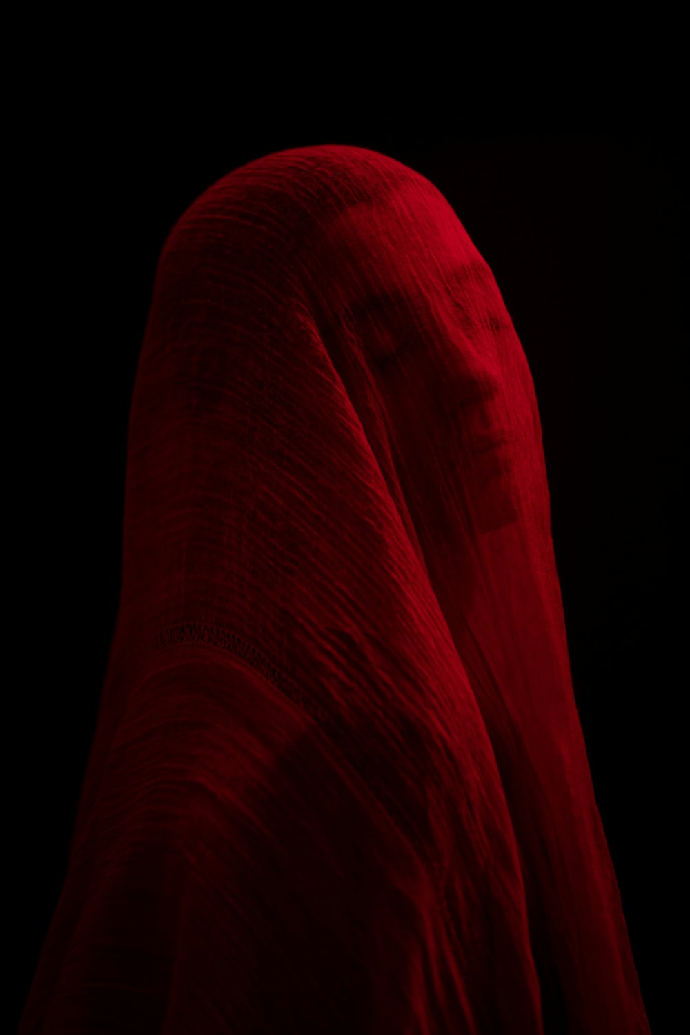 a woman's head covered in a red cloth