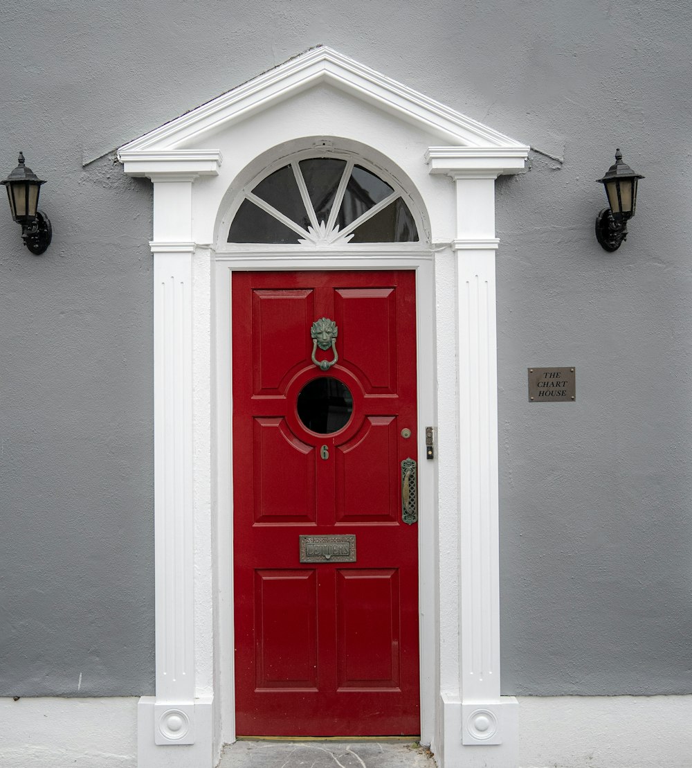 a red door with a white arch on a gray building