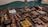 An assortment of chocolates displayed in a glass case. Each type of chocolate has a small sign indicating its flavor or filling, such as pecan, walnut, almond, and peanut. The chocolates are arranged in neat rows and vary in shape, size, and decoration.