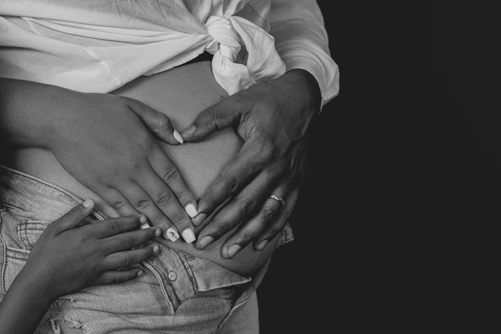 a black and white photo of a woman holding her stomach