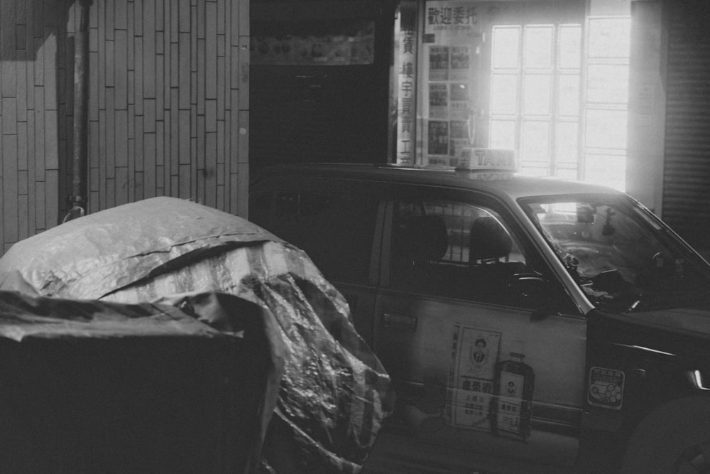 a black and white photo of a car parked in a garage