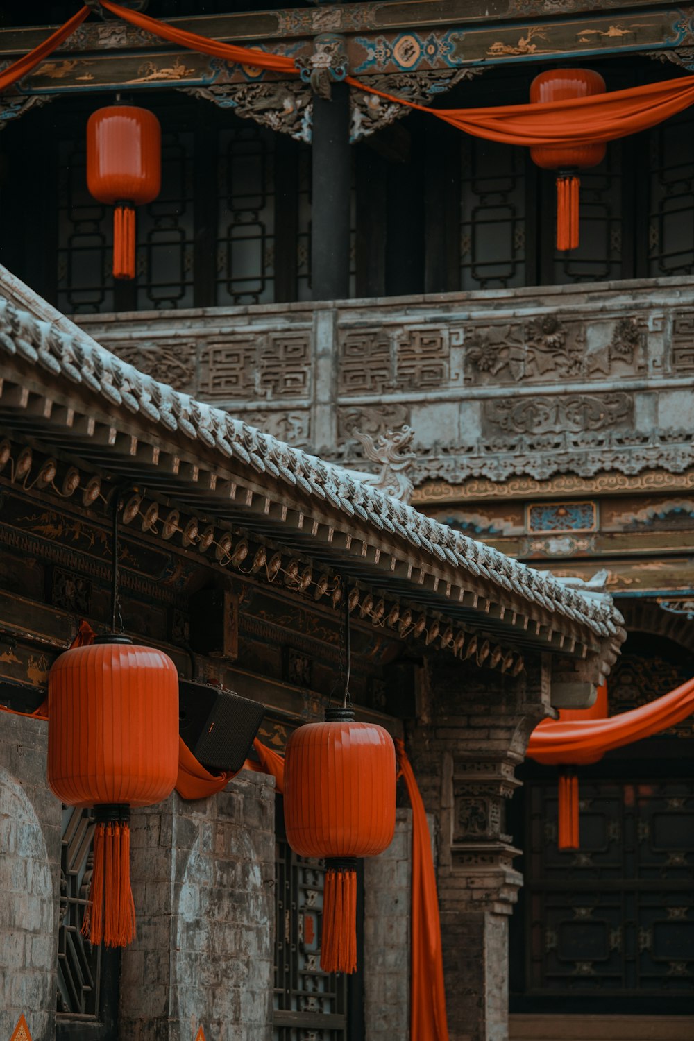 a couple of red lanterns hanging from the side of a building