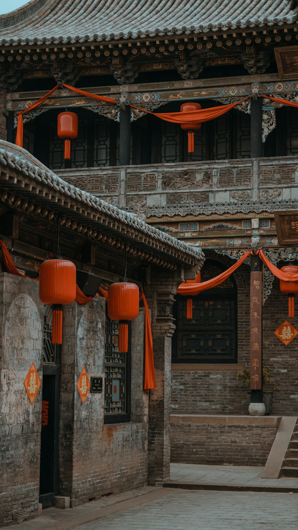 a building with orange lanterns hanging from it's roof