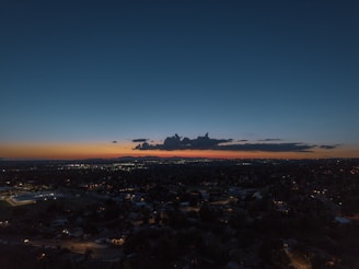 A serene sunset over Bangkok's skyline with vibrant city lights beginning to glow.