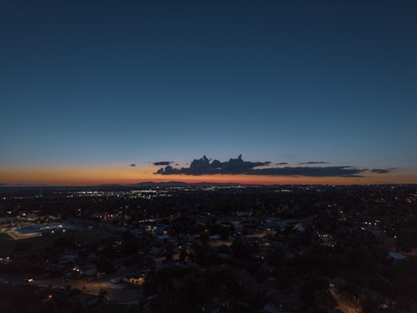 A serene sunset over Bangkok's skyline with vibrant city lights beginning to glow.