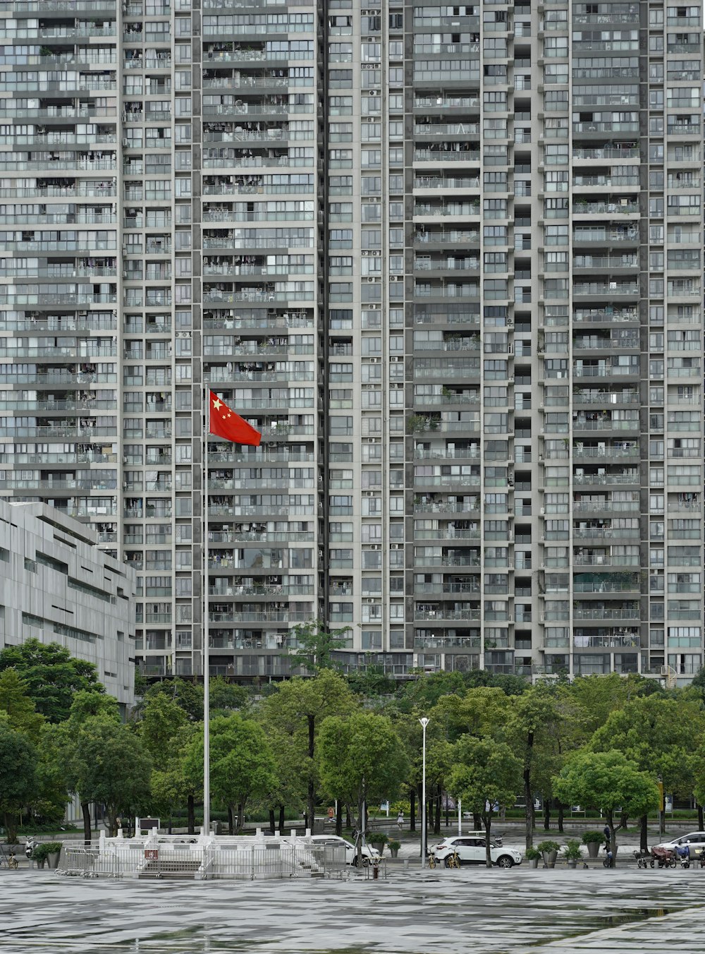 Un grand bâtiment avec un drapeau rouge devant lui