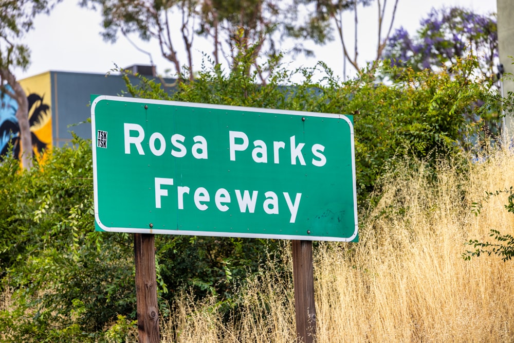 a green road sign that reads rosa parks freeway
