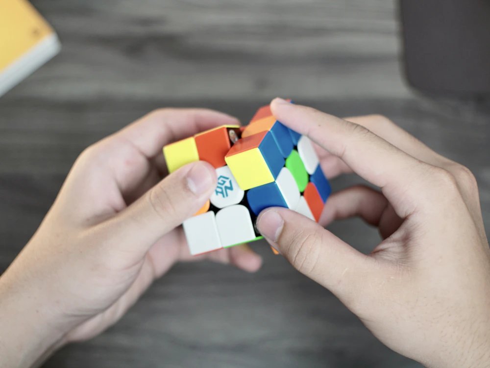 Hands turning a colorful 3x3 speed cube