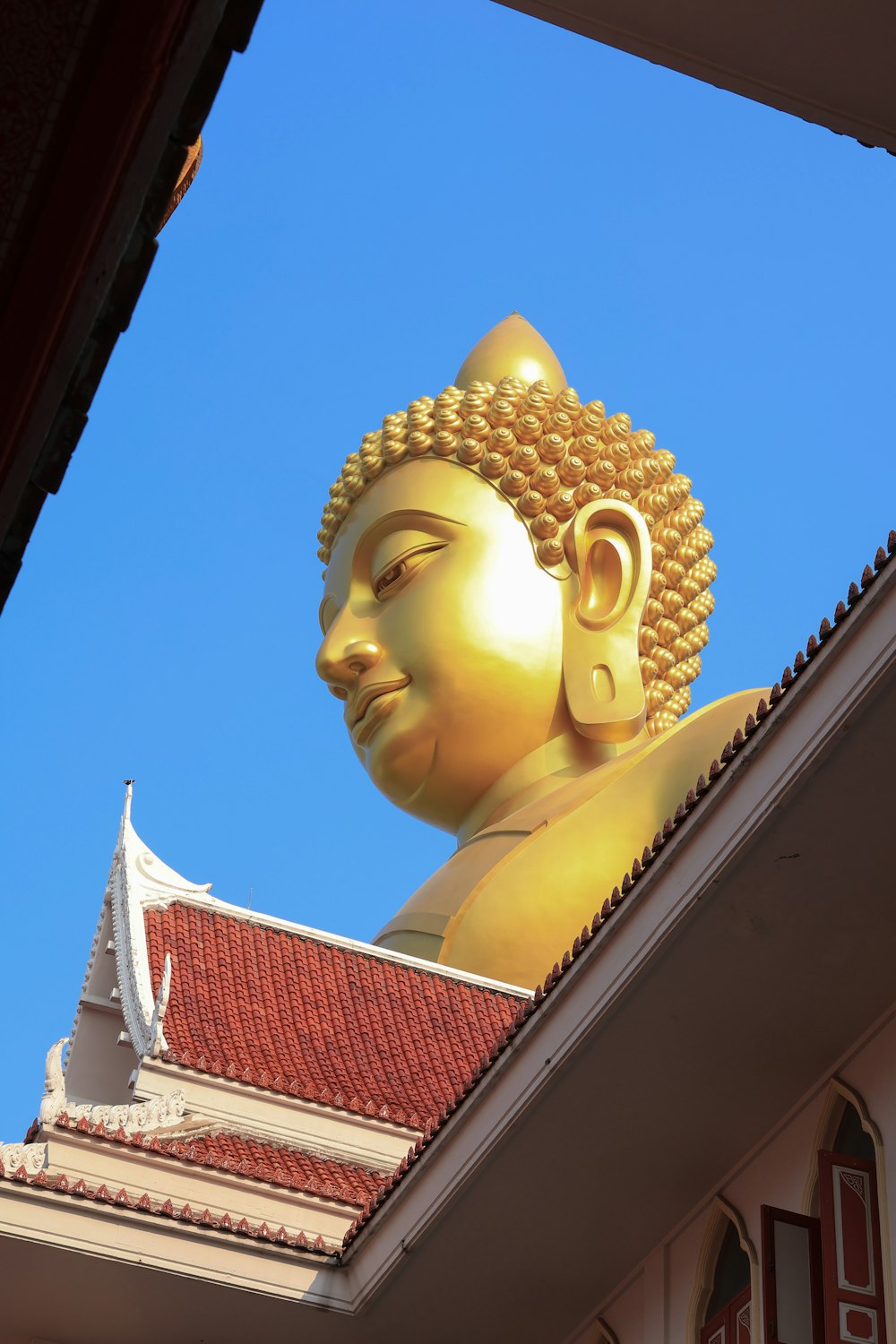 a golden buddha statue sitting on top of a building