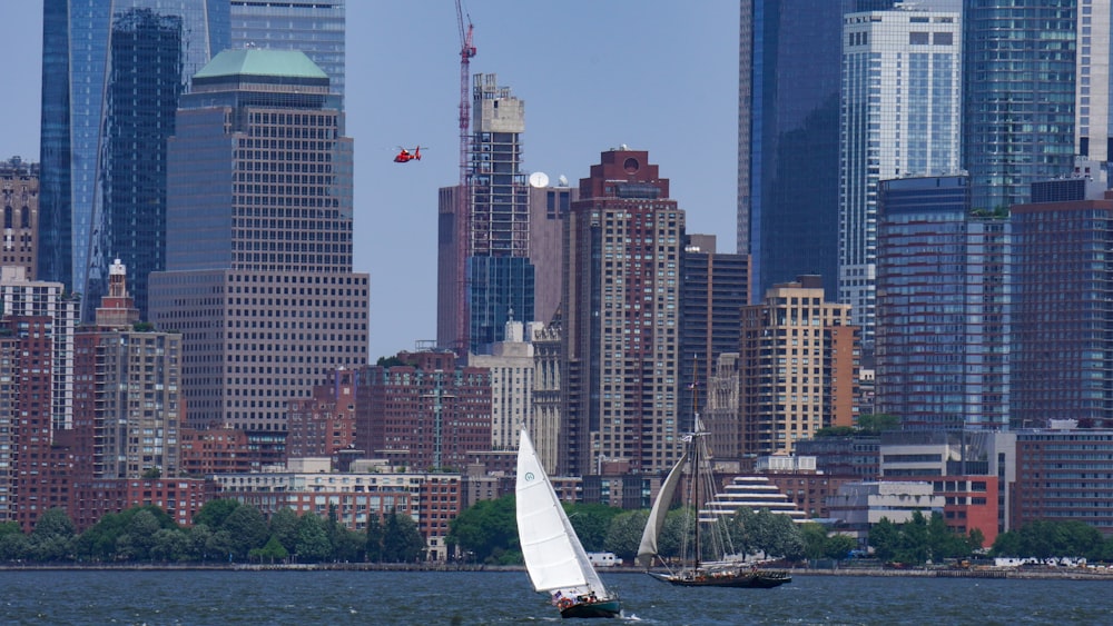 a sailboat in a body of water in front of a large city