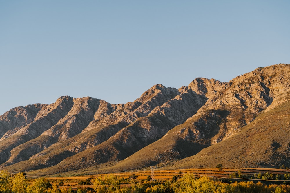 a mountain range with a train on the tracks in the foreground