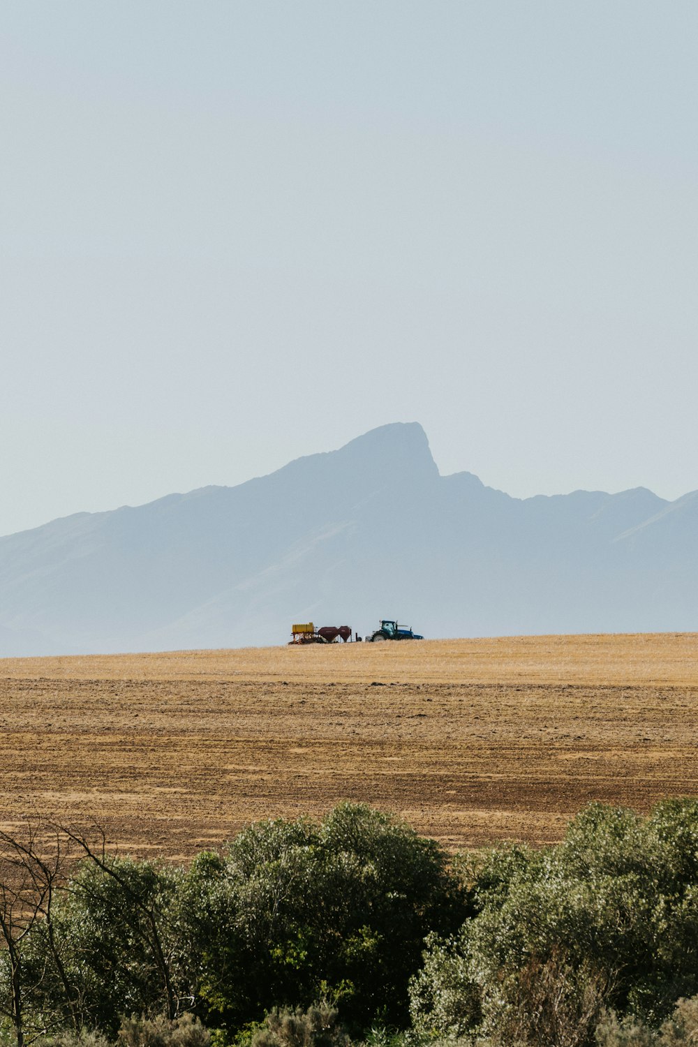 a large field with a couple of trucks in it