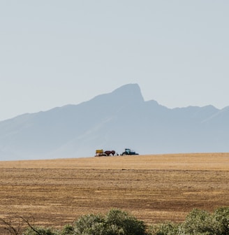 a large field with a couple of trucks in it