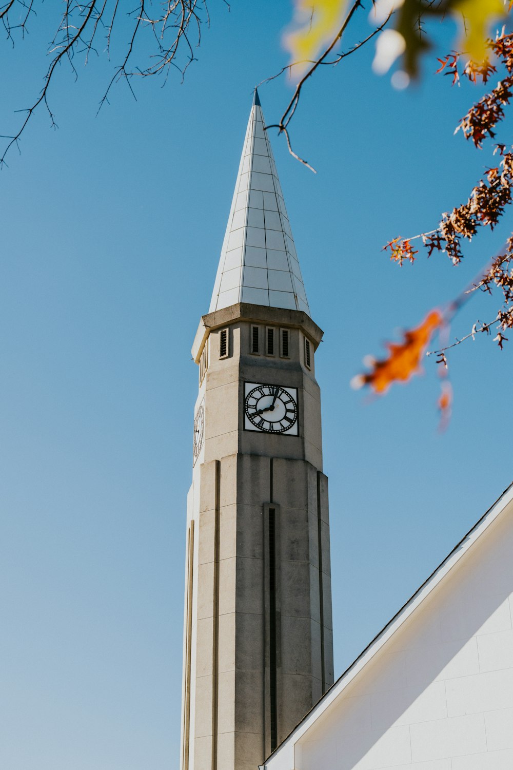 ein hoher Glockenturm mit einer Uhr auf jeder Seite