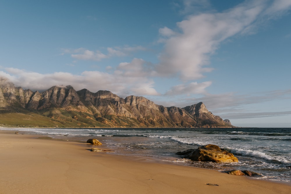 a sandy beach with a mountain in the background