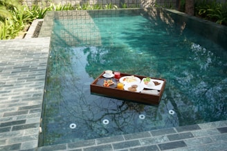 a tray of food sitting on the edge of a pool