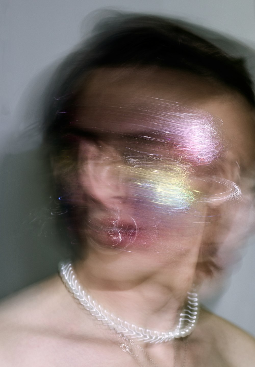 uma imagem borrada de uma mulher com um colar de pérolas