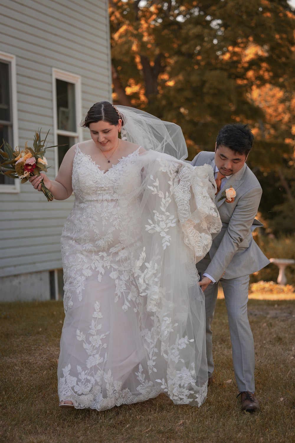a bride and groom walking in front of a house