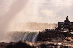 a large waterfall with a clock tower in the background
