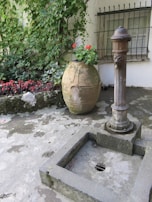A stone courtyard with ivy climbing the walls and a classic wrought-iron fountain at the center.