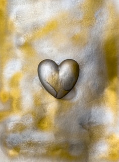 A ruby heart glowing warmly against a sleek, engineered metal background.