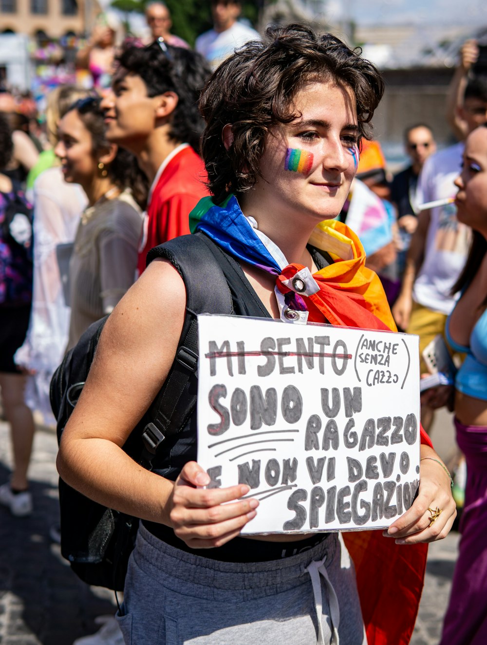 a woman holding a sign in front of a group of people