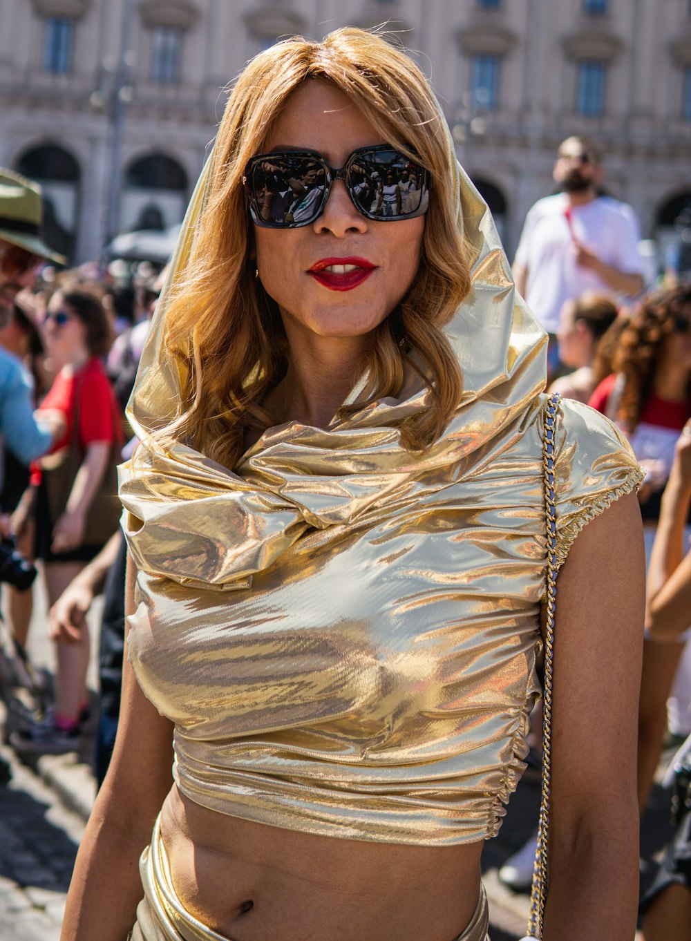 a woman wearing a gold outfit and sunglasses