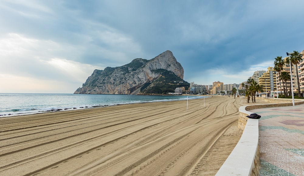 a sandy beach with a mountain in the background