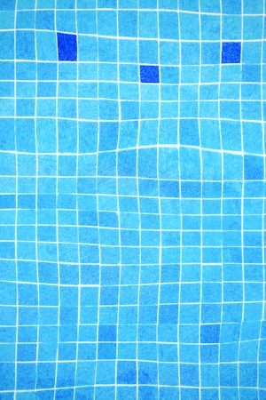 Piscine avec margelle et carrelage clair