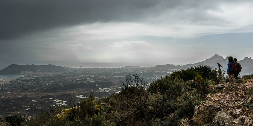 a person standing on top of a hill with a backpack