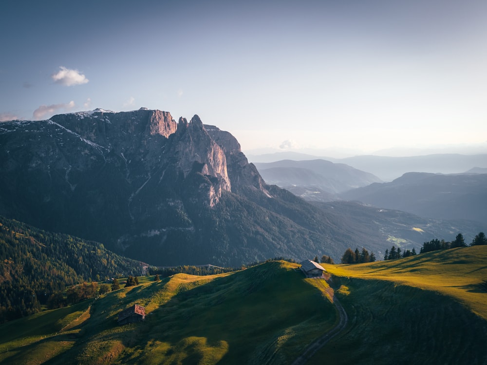 une vue d’une chaîne de montagnes avec une maison au premier plan