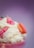 A dessert featuring whipped cream, small pink chocolate pieces labeled 'milk', and a pink macaron on top of the dessert. The background is a soft gradient of purple.
