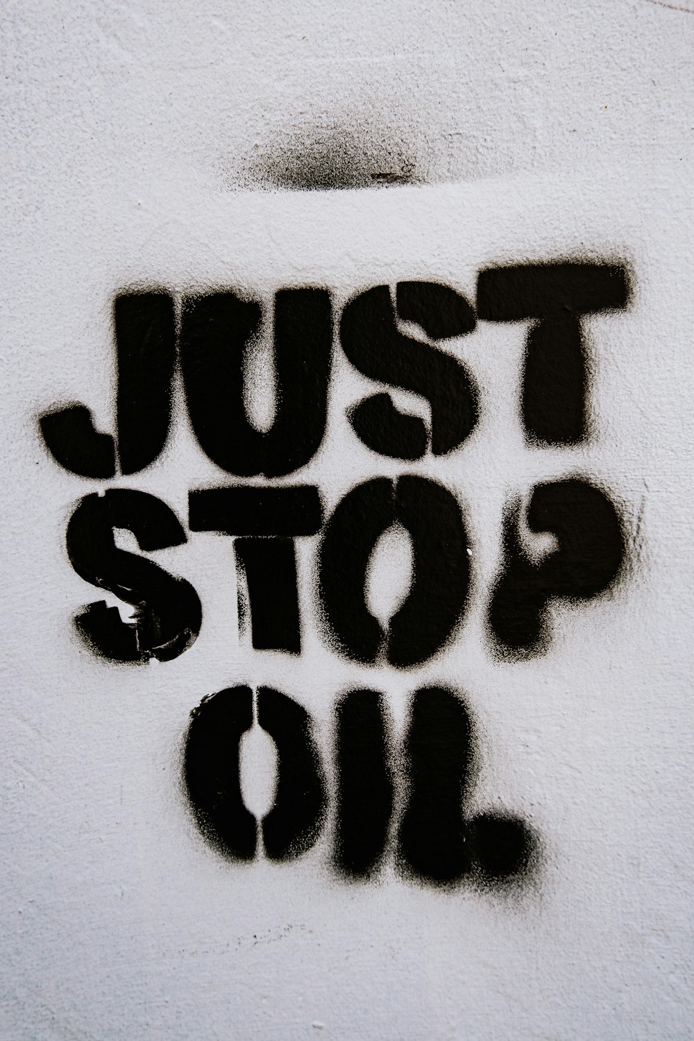 Un letrero pintado con aerosol que dice Just Stop Oil