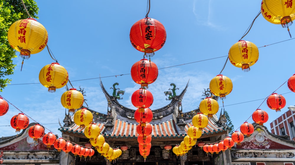 a group of red and yellow lanterns hanging from wires