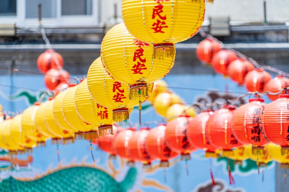 a group of yellow and red lanterns hanging from strings