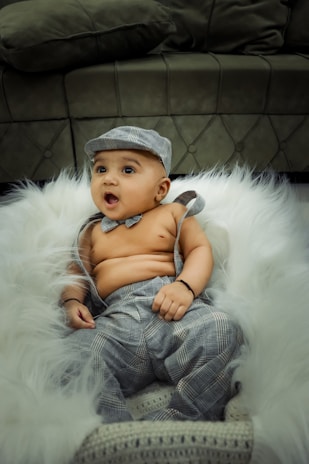 Long-sleeve bib in soft gray fabric displayed on a child’s chair.