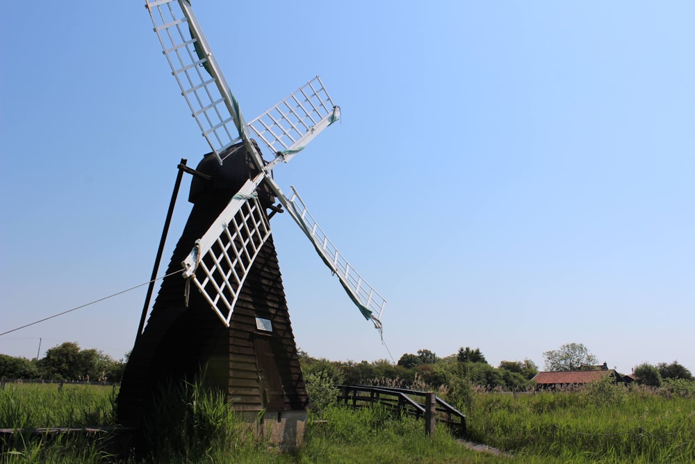 a windmill in the middle of a grassy field