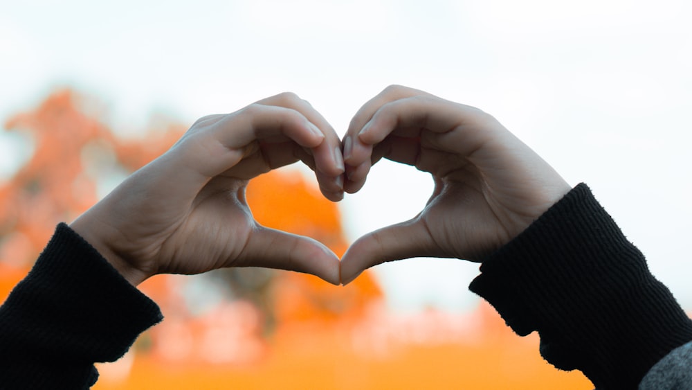 a person making a heart with their hands