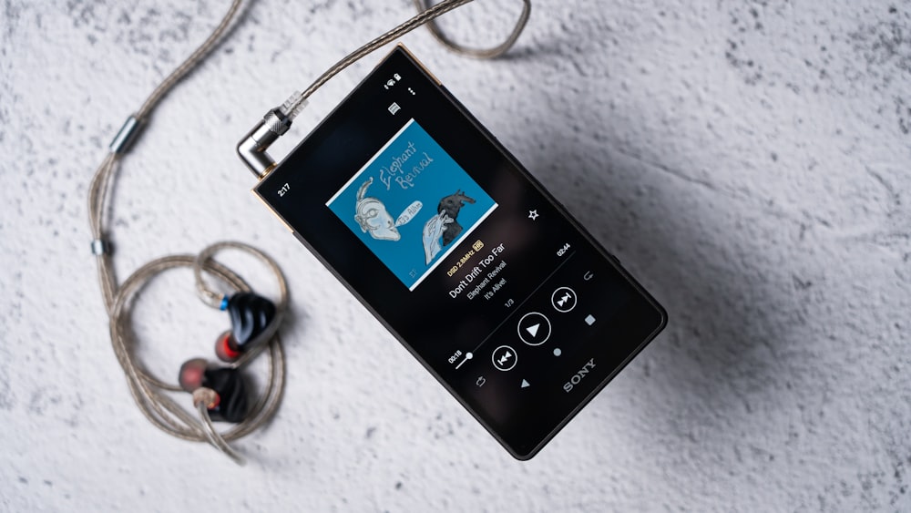 a black mp3 player sitting on top of a white floor