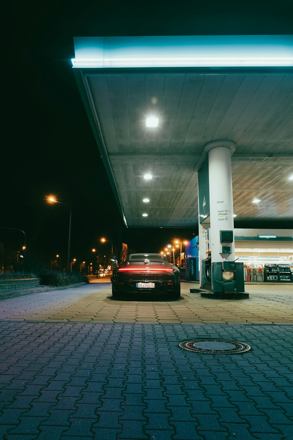 a red car parked in front of a gas station