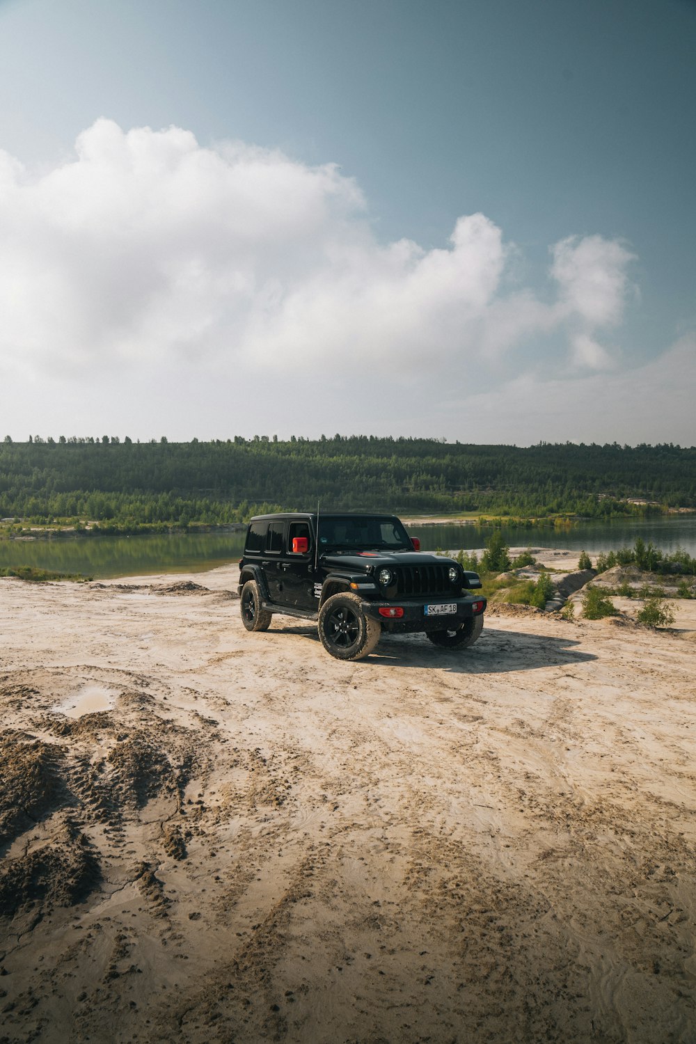 a black jeep is parked on a dirt road