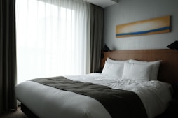 a bedroom with a large bed and a painting on the wall