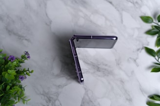 a close up of a cell phone on a marble surface