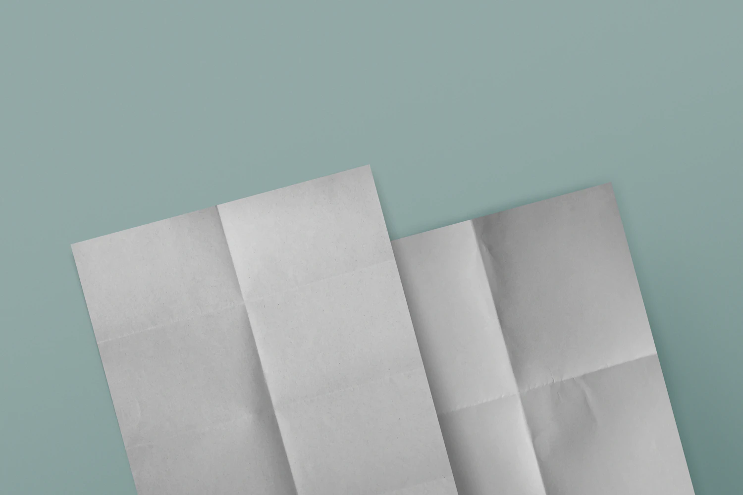 Three sheets of white kozo washi folded in half, laid on slate blue
