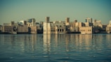 A serene boat ride along Dubai Creek with historic buildings in the background