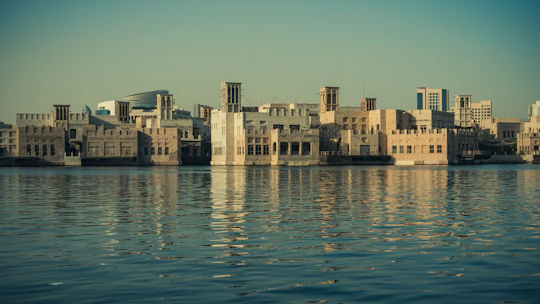 Sunset view over Dubai's historic Al Fahidi district with traditional wind towers.